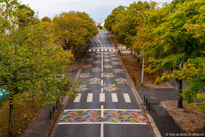Art urbain : quand toute la chaussée d'une rue devient un tableau aux motifs de tapisserie.