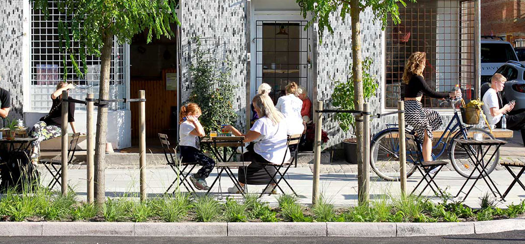 Une terrasse de café à Copenhague, au sol dallé de pavés climatiques dessinés parl’architecte et designer Flemming Rafn Thomsen, capables d’absorber les surplus d’eau de pluie et de les redistribuer à la végétation alentour.