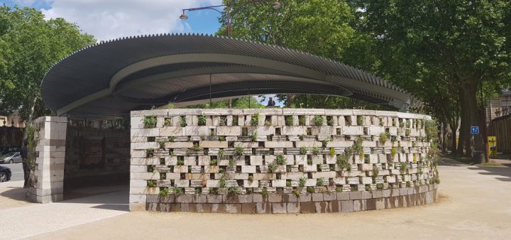 Biennale de l'architecture Ile de France 2022 : Vue du pavillon circulaire élaboré par l’agence ChartierDalix est constitué d’un immense mur de pierre habité par la faune et la flore sur sa face extérieure.