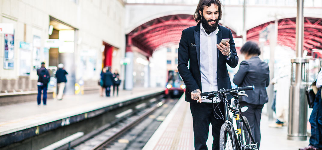 Un usager poussant son vélo sur un quai de gare.