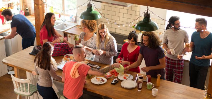 Un exemple de Coliving : Vue depuis la cuisine animée et chaleureuse d'une coloc où tout le monde s'affaire à la préparation du repas