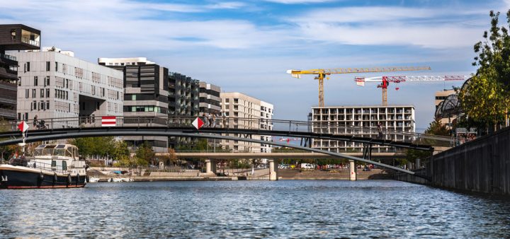 Projet de logements des maires : vue d'immeubles en construction au bord d'un fleuve.