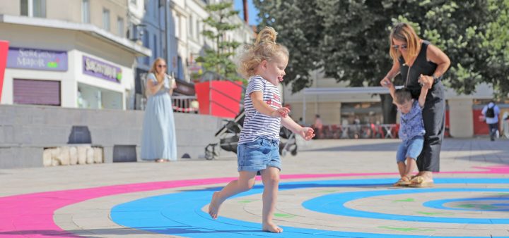 Design actif : parents et enfants jouant dans l'espace public sur de grandes formes colorés invitant à courir, sauter, etc. Crédit-Nicolas-Mahu