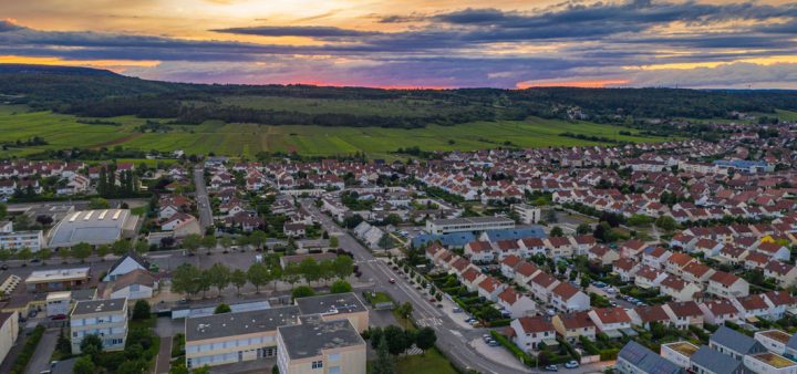 Coucher de soleil à l'arrière plan d'un paysage péri-urbain.