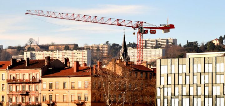 Crise du logement : une grue de chantier au milieu d'immeubles et bâtiments d'habitation.