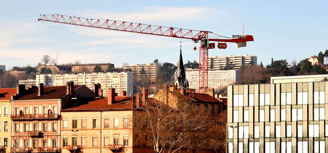 Crise du logement : une grue de chantier au milieu d'immeubles et bâtiments d'habitation.