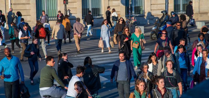 Décohabitation : des passant·e·s se croisant sur un passage piéton en fin d'après-midi.