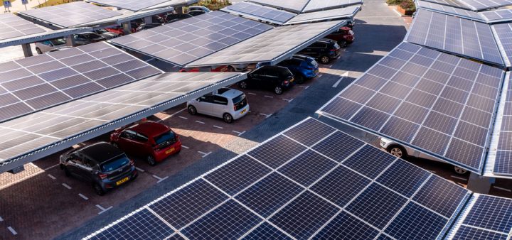 Vue en plongée d'un parking de stationnement muni d'ombrières avec panneaux solaires. ©Istock