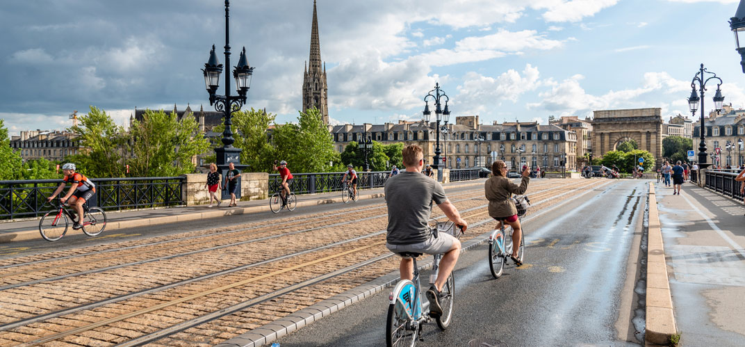Décarbonation des villes en France : un pont du centre-ville bordelais avec des pistes piétonnes, cyclables et au centre les rails du tramway.