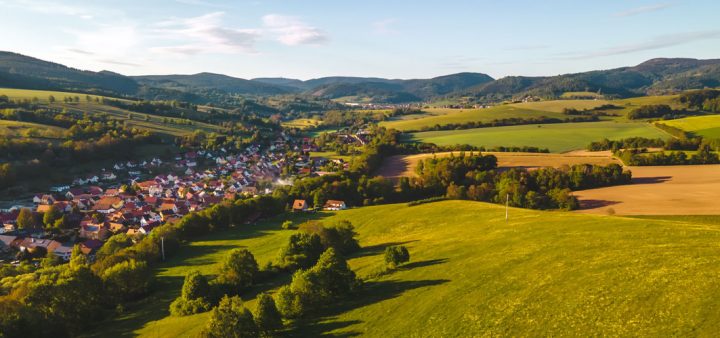 Croissance économique et sobriété foncière : un village de pavillons entourés de champs, d'arbres et de prairie.