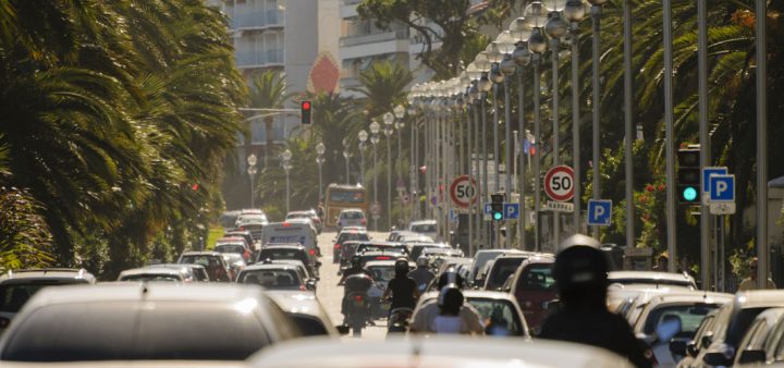 Bruit : un embouteillage en plein centre-ville sur une route bordée de palmiers.