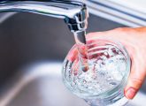 Prix de l'eau : une main se servant un verre d'eau au robinet
