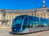 Interview de Christine Bost , "les transports sont la colonne vertébrale de la ville" : Un tram sur une place de centre-ville historique.