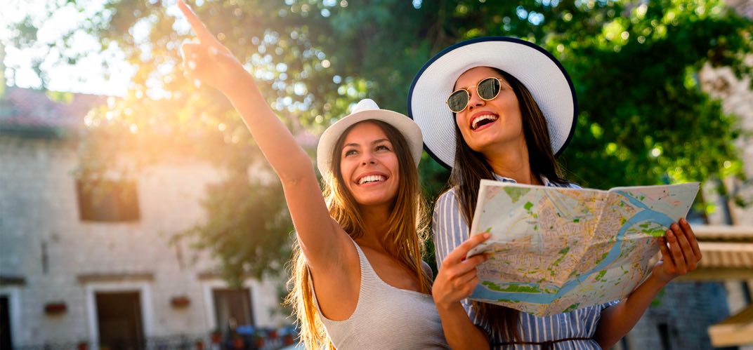 Agences d'attractivité :deux jeunes touristes, plan de la ville en main.