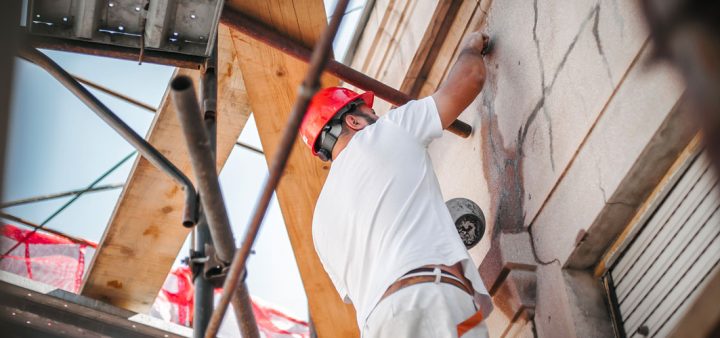 Etude de l'IDHEAL sur le logement : un ouvrier travaillant sur façade d'un bâtiment en rénovation.