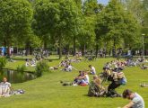 Bien-être territorial : des citoyens et citoyennes profitant du soleil sur les pelouses d'un parc public